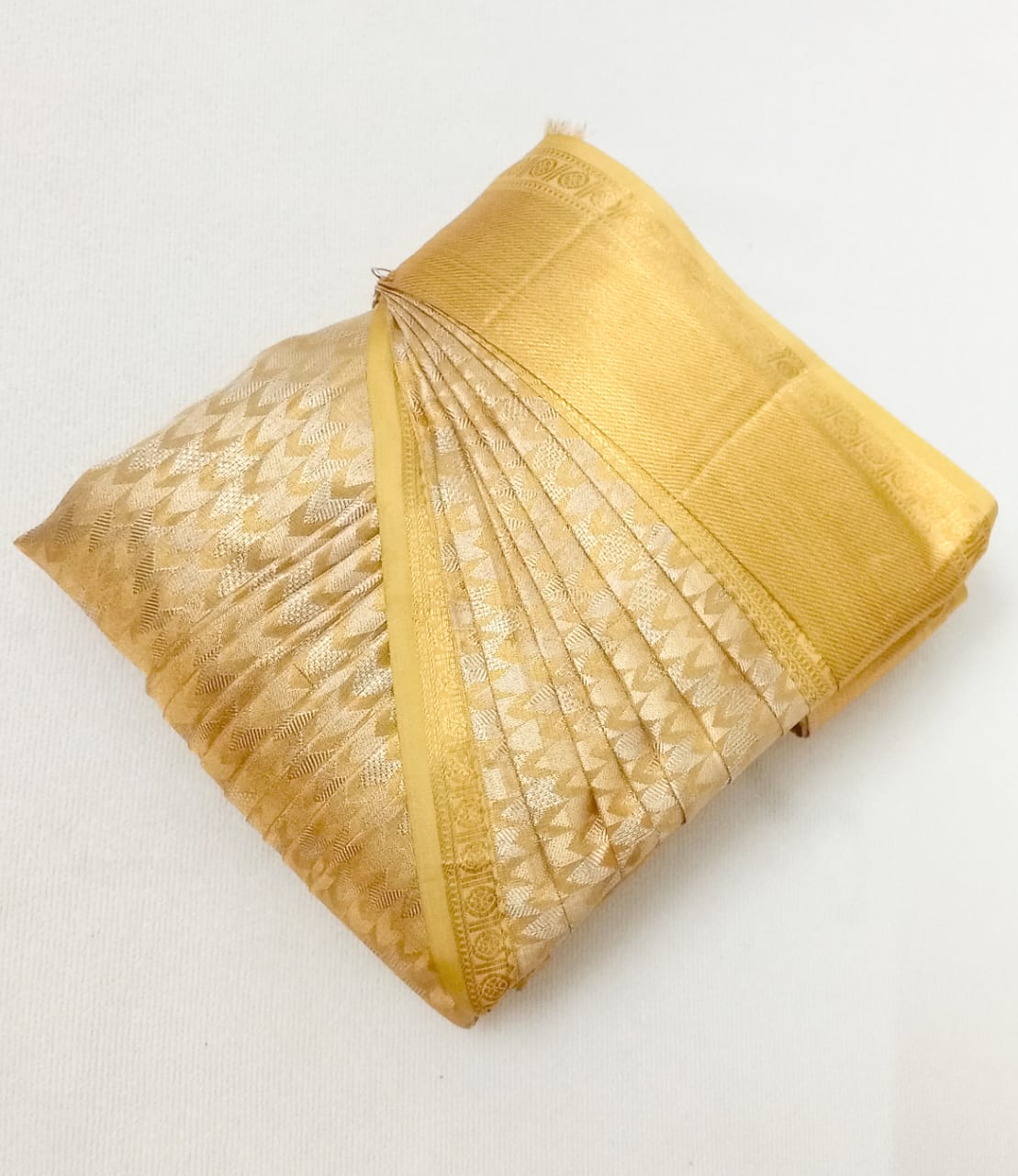 Woman draped in a perfectly pleated saree, showcasing elegance.